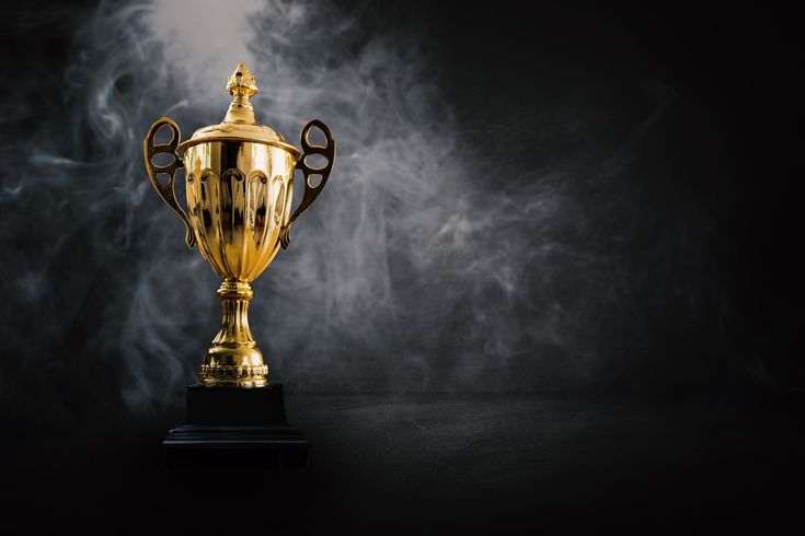 A golden trophy cup standing in dark smoke