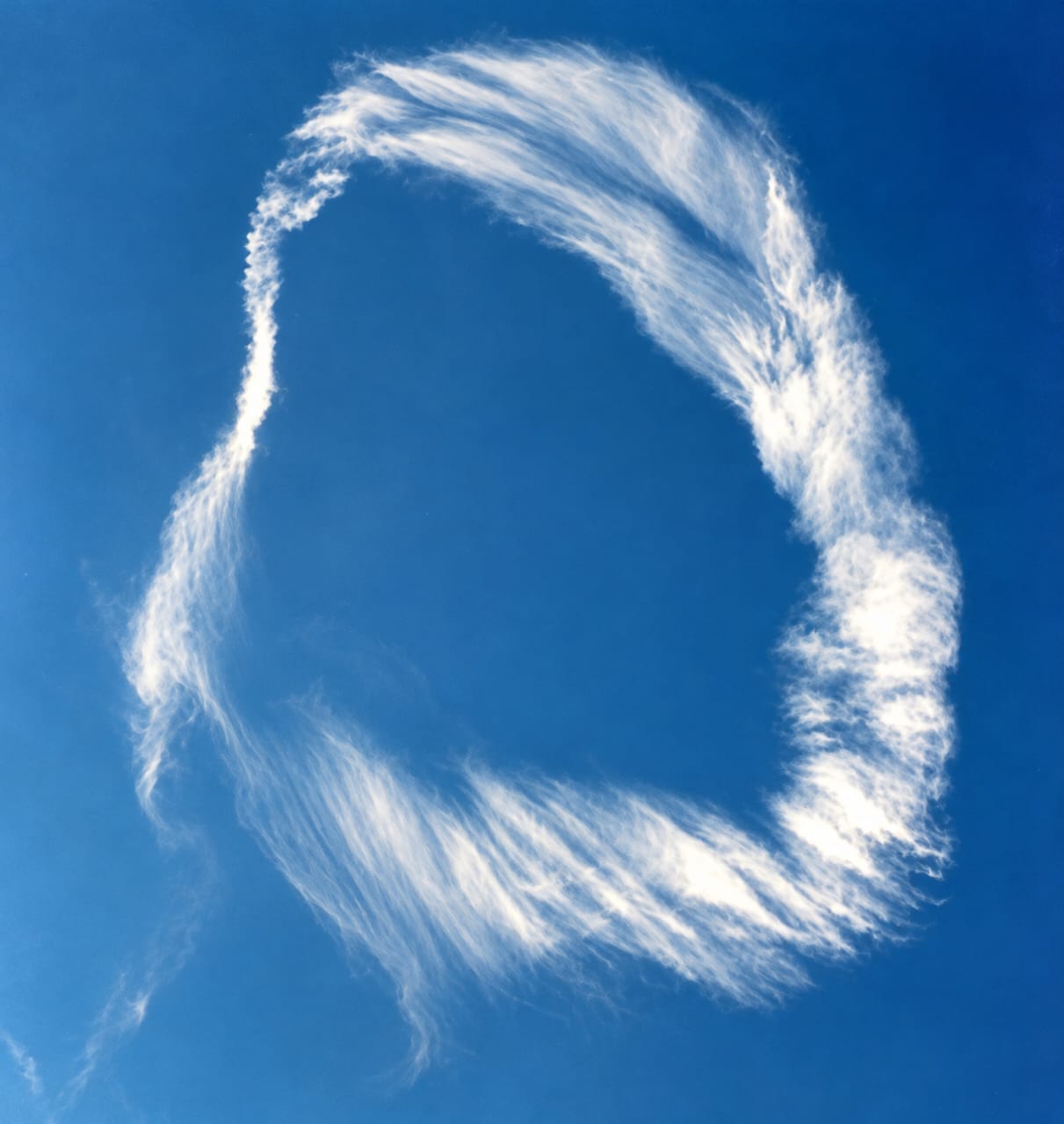 A ring-shaped cloud against a deep blue sky